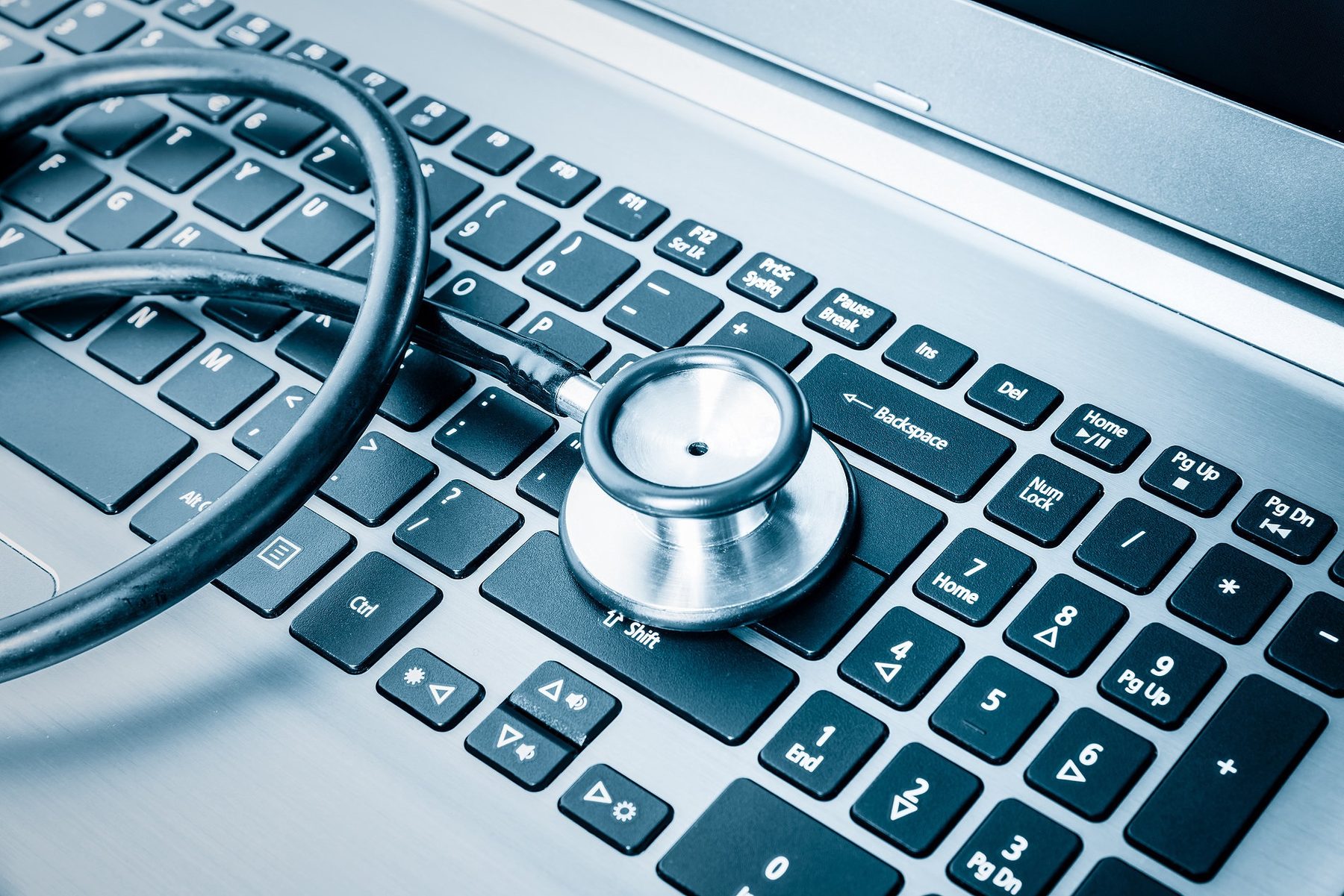Stethoscope resting on a laptop keyboard, symbolising IT diagnostics and repair